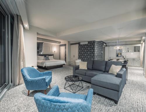 a living room with blue furniture and a bedroom at Le Capitole Hotel in Quebec City