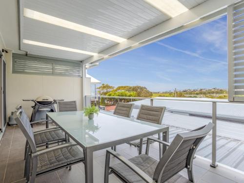a dining room with a table and chairs on a balcony at Kiama Sunrise Kiama in Kiama
