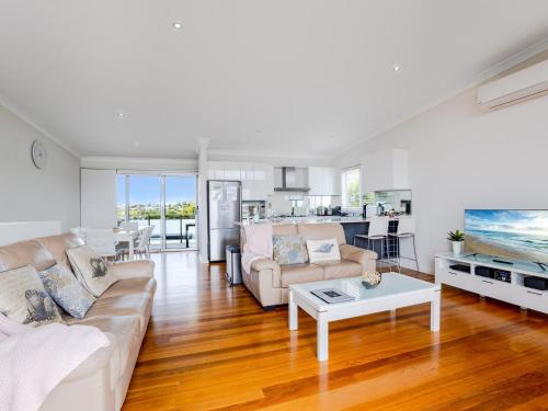 a living room with a couch and a table at Kiama Sunrise Kiama in Kiama
