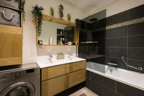 Stylish New 1 bedroom apartment in juan les pins في أنتيب: حمام مع مغسلة وغسالة ملابس
