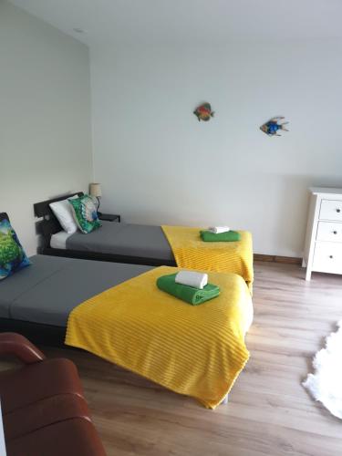 a living room with two beds with yellow blankets at Marisol Sunset in Charneca