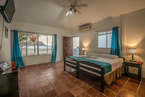 um quarto com uma cama com cortinas azuis em Hotel Mozonte San Juan del Sur em San Juan del Sur