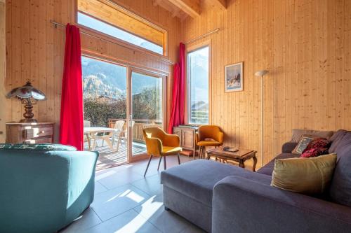 un salon avec un canapé et une grande fenêtre dans l'établissement Family Cottage With Balcony In Chamonix, à Chamonix-Mont-Blanc