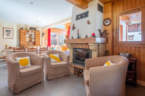 un salon avec deux chaises et une cheminée dans l'établissement Family Cottage With Balcony In Chamonix, à Chamonix-Mont-Blanc