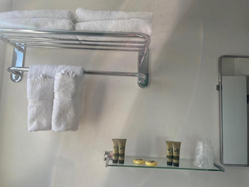 a bathroom with towels on a shelf and a mirror at Ephrata Inn Motel in Ephrata