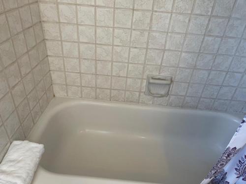 a white bath tub sitting next to a white sink at Ephrata Inn Motel in Ephrata