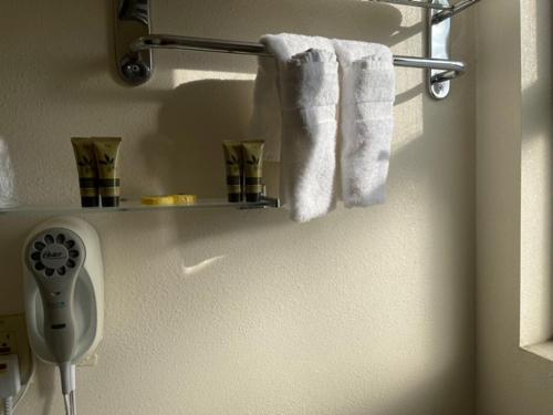 a bathroom with towels hanging on a wall at Ephrata Inn Motel in Ephrata
