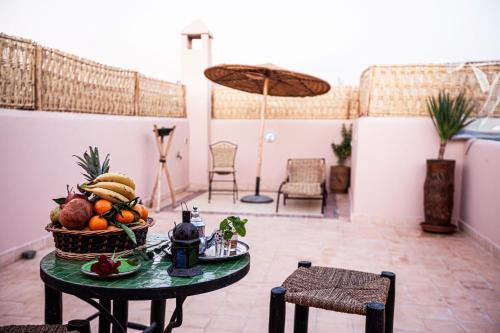 Zimmer mit einem Tisch und einem Obstkorb in der Unterkunft Riad Taziri in Marrakesch