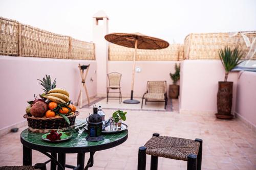 マラケシュにあるRiad Taziriのテーブルとフルーツバスケット付きの部屋
