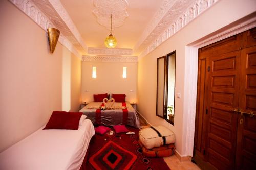 ein kleines Schlafzimmer mit 2 Betten und einer Tür in der Unterkunft Riad Taziri in Marrakesch