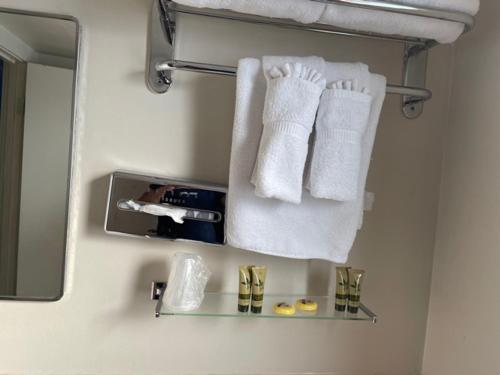a bathroom with white towels and a mirror at Ephrata Inn Motel in Ephrata