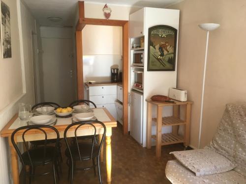 une petite cuisine avec une table et des chaises dans une pièce dans l'établissement Serre-Chevalier-Chantemerle. Studio Plein Sud 4per, à Saint-Chaffrey