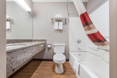 a bathroom with a toilet and a bath tub at Red Roof Inn & Suites Omaha - Council Bluffs in Council Bluffs