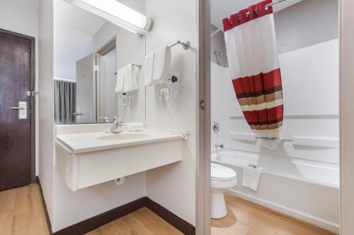 a white bathroom with a sink and a toilet at Red Roof Inn & Suites Omaha - Council Bluffs in Council Bluffs
