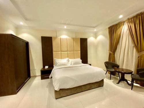 فندق سكاي بلو في الباحة: غرفة نوم بسرير ومكتب وطاولة