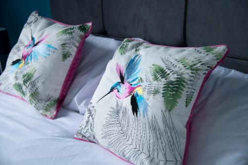 two pillows with birds on them on a bed at Cosy Stays in Redcar