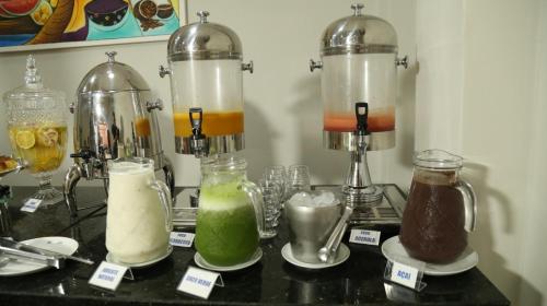 a counter with three different types of drinks in jars at Prata Hotel in Santarém