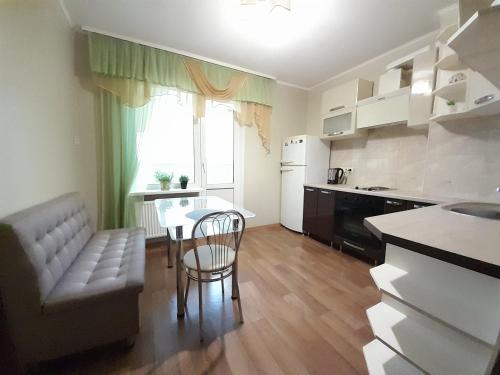 uma cozinha e sala de estar com uma mesa e um sofá em UpTown-Квартира em Vyshhorod