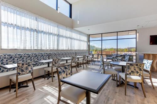 a dining room with tables and chairs and windows at Best Western Plus Executive Residency Phoenix North Happy Valley in Phoenix