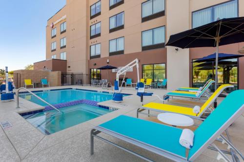 a pool at a hotel with chairs and an umbrella at Best Western Plus Executive Residency Phoenix North Happy Valley in Phoenix