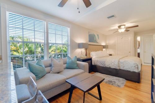 a living room with a couch and a bed at Tropical Nola Studio Vacation Rental in West Palm Beach