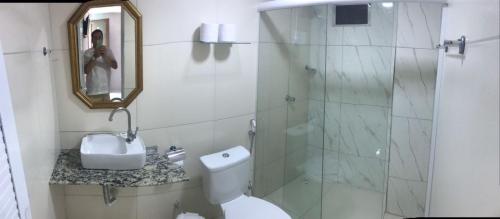 a bathroom with a toilet and a glass shower at Pousada Brasil Tropical in Bezerros
