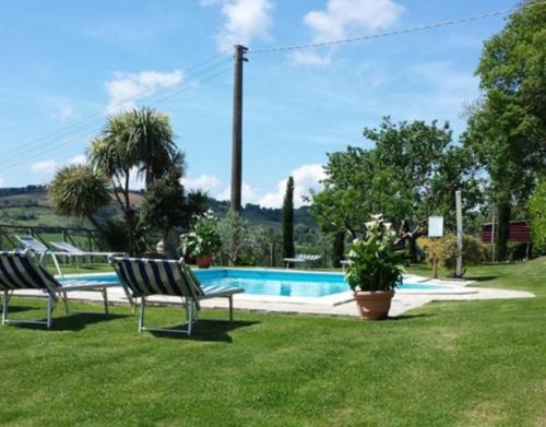 un patio con 2 sillas y una piscina en Agriturismo Il Maggio, en Manciano