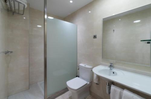 a bathroom with a toilet and a sink and a shower at Apartamentos Caracas in Torremolinos