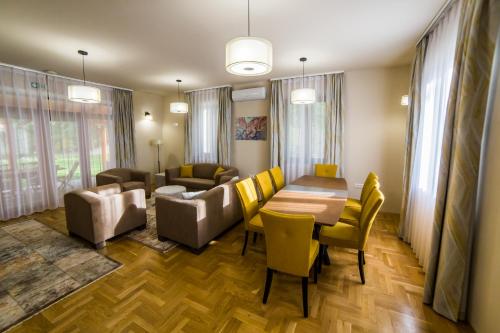 a living room with a table and yellow chairs at Haracsi Vendégház in Zselickisfalud