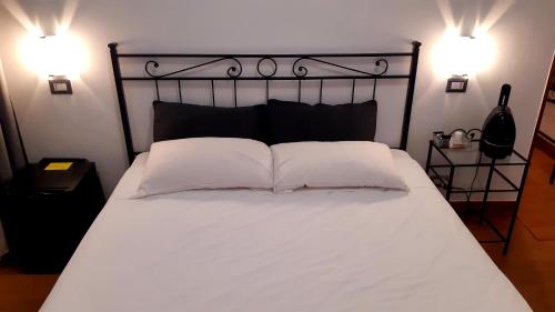 a bedroom with a white bed with two pillows at Guest House Masterintrastevere in Rome