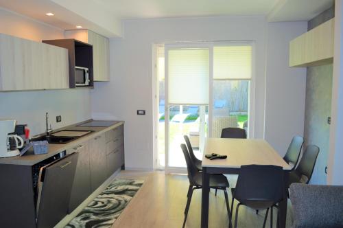 een keuken met een tafel en stoelen bij Appartamento Campagnola con giardino privato e due camere da letto in Riva del Garda