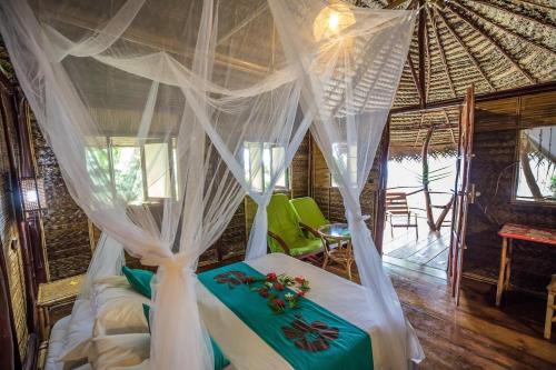 Pension TUPUNA في Haapu: غرفة نوم بسرير مع مظلة