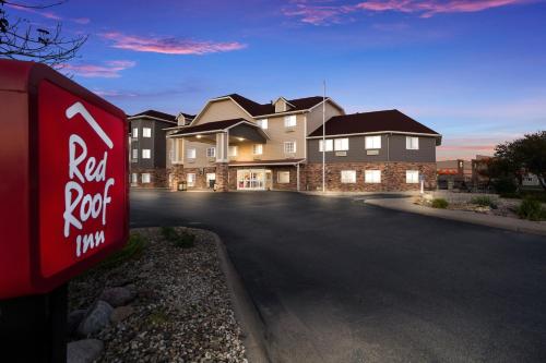a real roof inn sign in front of a house at Red Roof Inn & Suites Omaha - Council Bluffs in Council Bluffs