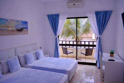 a bedroom with a bed and a couch and a balcony at Aparthotel Santa Maria Beach in Santa Maria