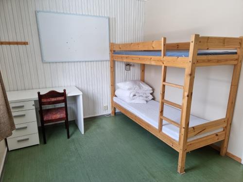 a bedroom with a bunk bed with a desk and a ladder at Stetinden National Mountain Lodge in Kjøpsvik