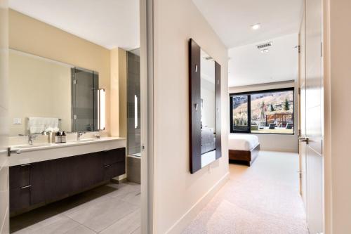 a bathroom with a sink and a bed and a mirror at Lift Park City Condominiums in Park City