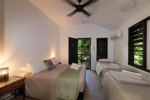 a bedroom with two beds and a ceiling fan at Cape Trib Beach House in Cape Tribulation