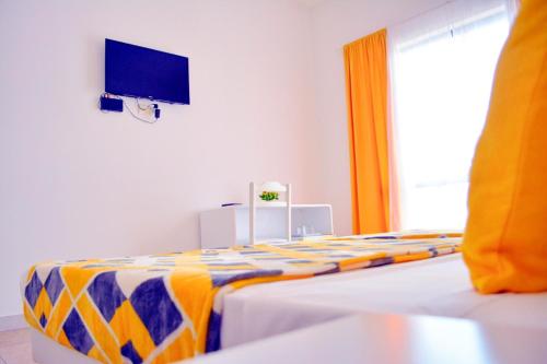 a bedroom with a bed and a tv on the wall at Aparthotel Santa Maria Beach in Santa Maria