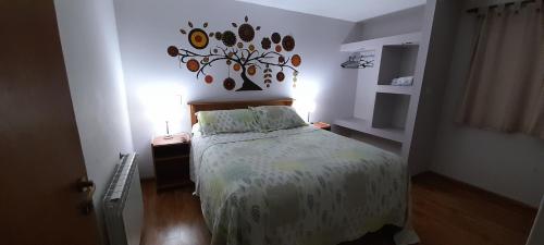 a bedroom with a bed with a floral bedspread at MViejo in Puerto Madryn