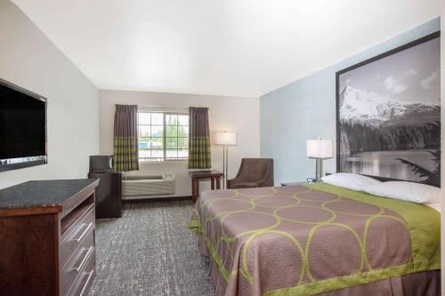 Habitación de hotel con cama y TV de pantalla plana. en Gateway Inn & Suites Eugene-Springfield, en Eugene