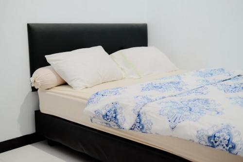 a bed with blue and white sheets and pillows at Wisma 88 in Gorontalo