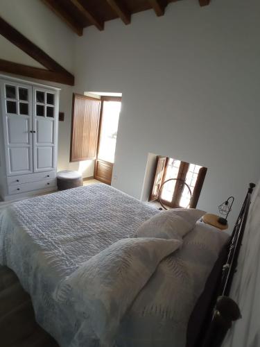 a bedroom with a large bed and a window at Casa Rural Abuela Luci in Santibáñez de Béjar