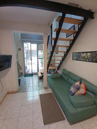 a living room with a green couch and stairs at Jardin Secreto in Rosario