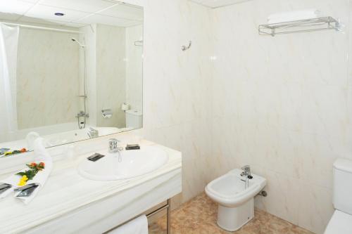 a white bathroom with a sink and a toilet at HSM Canarios Park in Calas de Mallorca