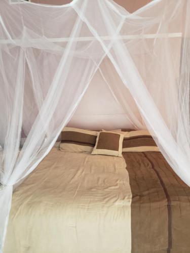 Una cama con mosquiteros blancos. en Relaxing Stay in the Country Unit 1, en Ozark