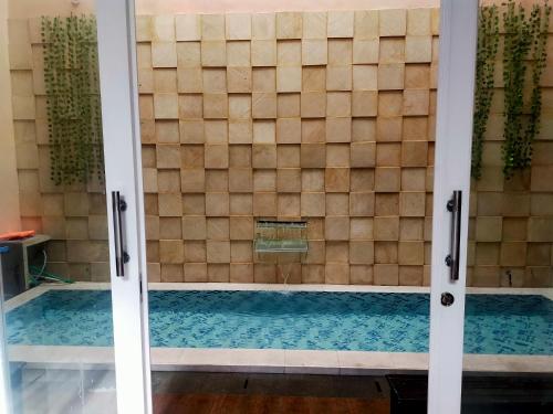 a shower with a glass door in a bathroom at Villa keluarga Pandansari in Malang