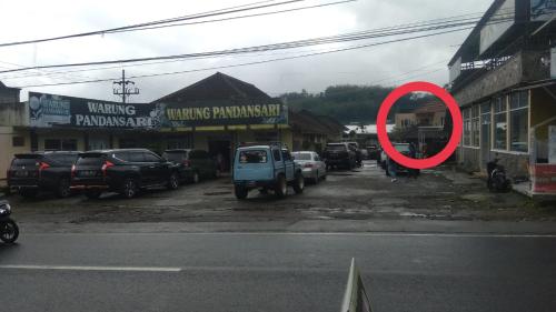 un cerchio rosso sul lato di una strada con le auto di Villa keluarga Pandansari a Malang
