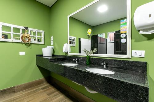 łazienka z 2 umywalkami i dużym lustrem w obiekcie RESORT PARTICULAR perfeito p/ famílias com crianças e grupos w Foz do Iguaçu