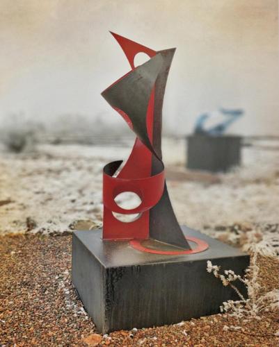 a red and black statue sitting on the beach at CASA FARO ARTE in Potrerillos