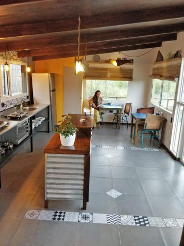 a kitchen with a person sitting at a table in a room at CASA FARO ARTE in Potrerillos